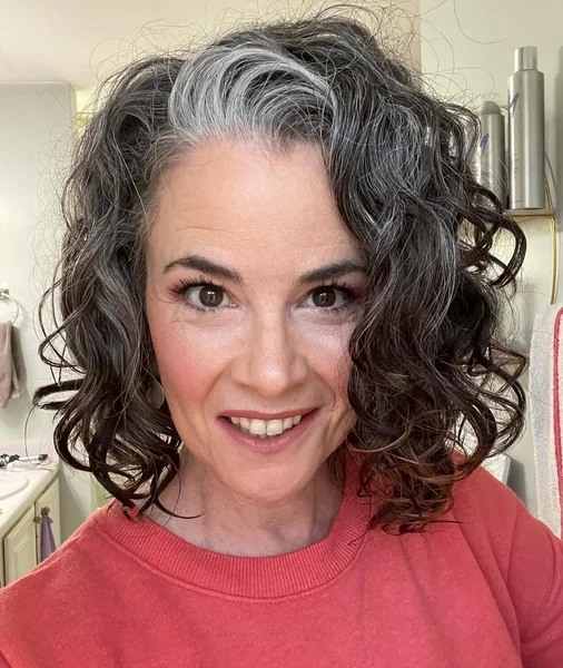 Mid-Length Curly Bob with Bold Silver Streak