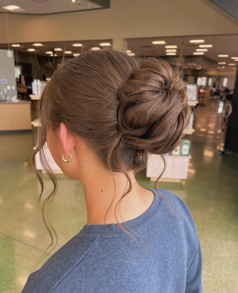 Voluminous Messy Bun Updo with Soft Tendrils