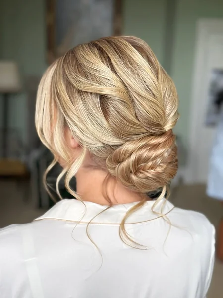 Elegant Dark Low Braided Bun with Face Tendrils