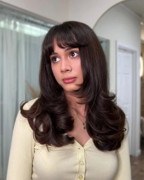Glamorous Layered Blowout with Deep Fringe Bangs
