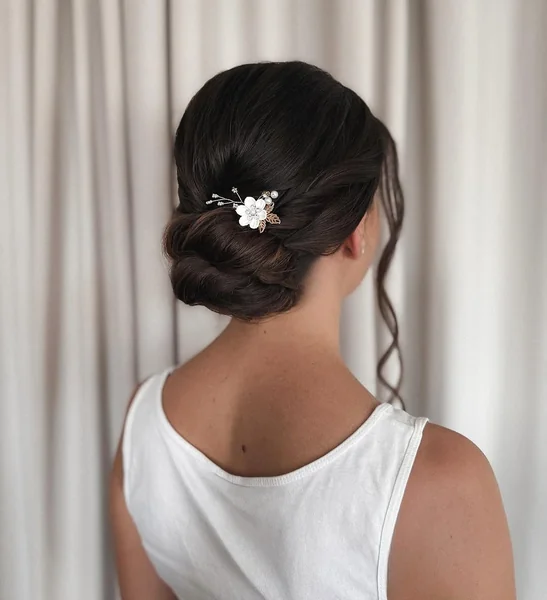 Romantic Deep Brunette Low Bun with Floral Pin