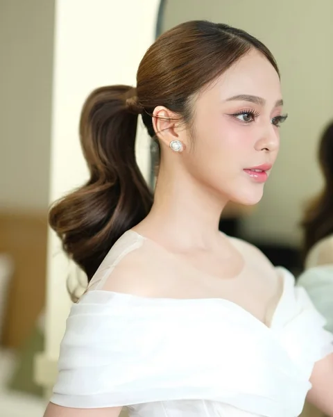 Sleek and Sculpted Bridal Ponytail with Bouncy Waves