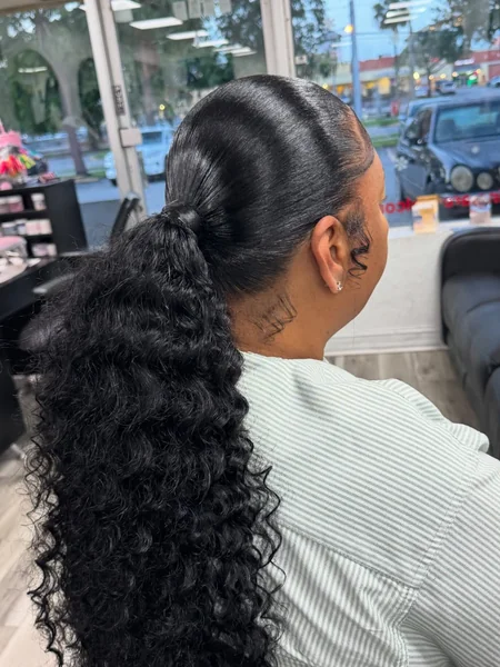 Slicked Low Ponytail with Dramatically Defined Curls