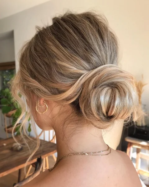 Chic Low Messy Bun with Face-Framing Tendrils