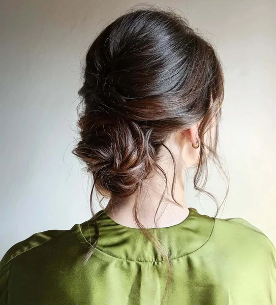 Effortless Low Messy Bun with Face-Framing Tendrils