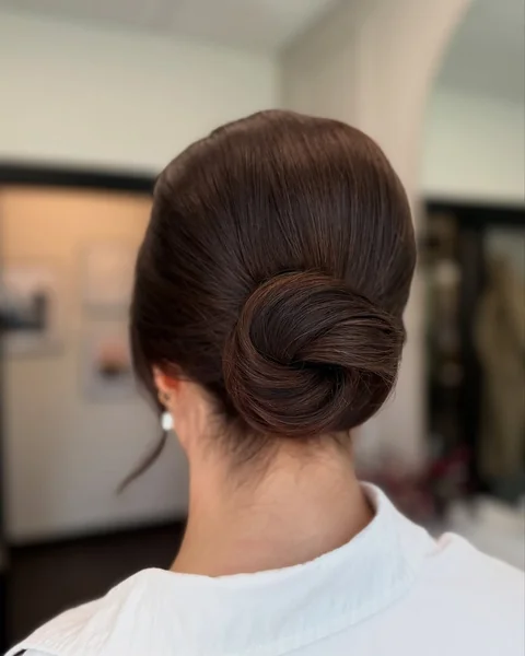 Sculpted High Bun with Dramatic Side-Swept Bangs