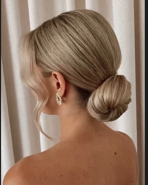 Sleek Low Chignon with Soft Face-Framing Tendrils