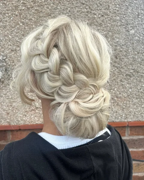 Sophisticated Ash Blonde Low Chignon with Soft Curtain Bangs