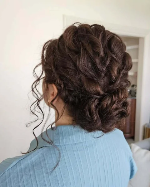 Textured Brunette Low Bun with Romantic Tendrils