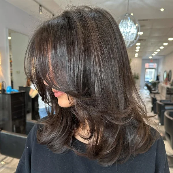 Voluminous Chocolate Brown Layers with Sweeping Butterfly Bangs