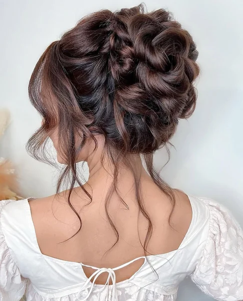 Voluminous High Bun with Elegant Side-Swept Ringlets
