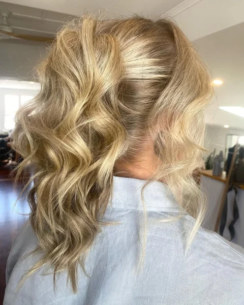 Side-Swept Braided Ponytail with Voluminous Curls